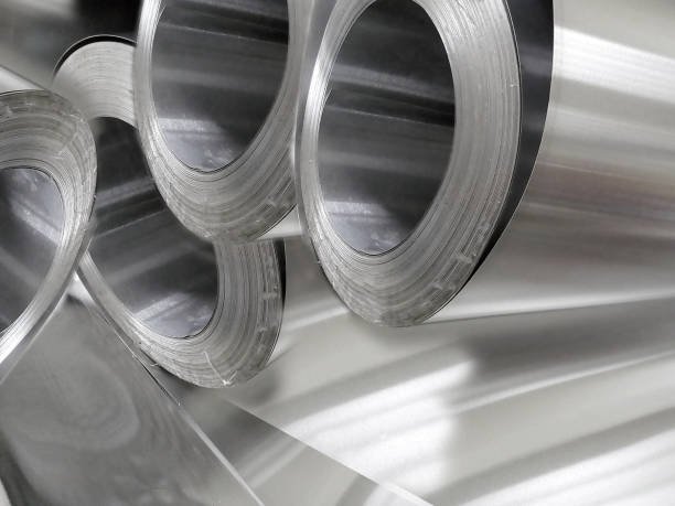 four rolls of industrial aluminum metal material in industrial room.