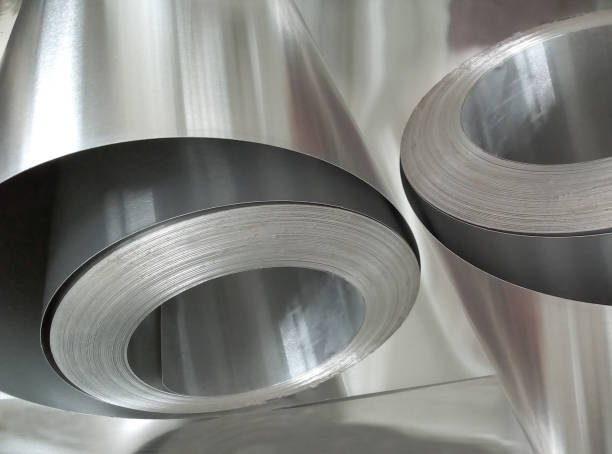 two rolls of aluminum metal in an industrial room. thin and shiny metal